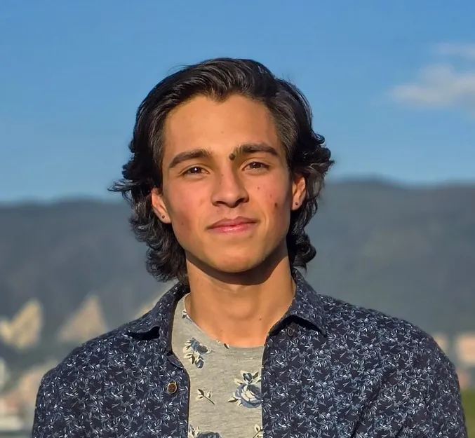 Sebastián Villota sonriendo, con los cerros de Bogotá detrás